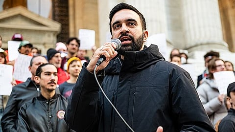 In the image Zohran Mamdani is shown adressing the audience in a campaign