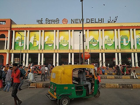 In the image New Delhi railway station is shown with crowd outside it