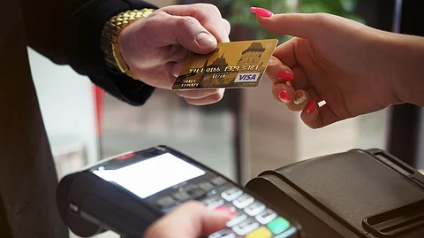 In the image a person is giving his credit card to someone