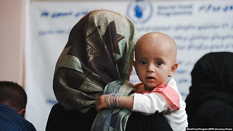 An Afghani woman holding her child in arms.