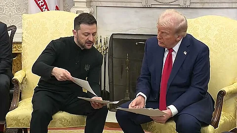 Trump sitting with Zelenskyy and showing some documents.