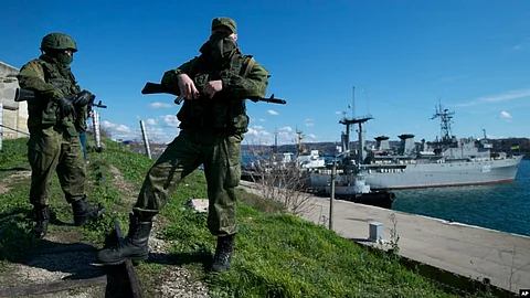Russian soldiers guard a pier where two Ukrainian naval vessels are moored in Sevastopol, on the Crimean Peninsula, on March 5, 2014.