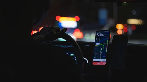 A cab driver using GPS at night.