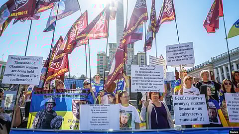 Relatives of missing Ukrainian soldiers hold flags and signs while attending a rally