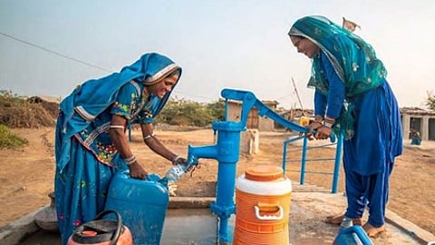 Woman filling water from handpump