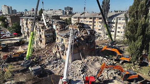 Rescuers conduct a search and rescue operation in and around a residential building heavily damaged during a large-scale Russian attack on Kyiv on August 28.