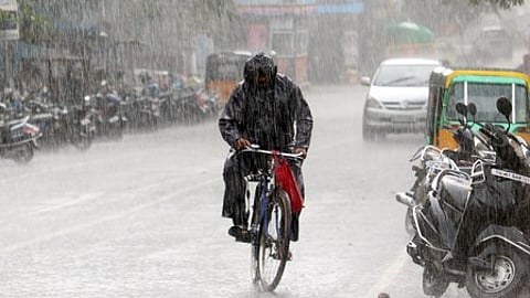 Chennai: A man wearing a raincoat cycles through a rain-soaked road during showers in Chennai on Wednesday, July 02, 2025.