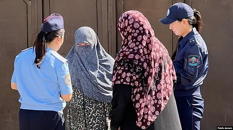 Female police officers in Osh speak to local women during a raid to enforce the niqab ban.