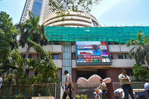 Mumbai: People walk past a screen showing stock market goes down outside BSE building at Dalal Street after the counting of votes for Lok Sabha polls, in Mumbai on Tuesday, June 4, 2024.