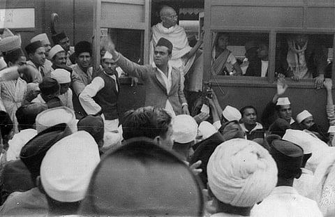 Mahatma Gandhi in a train with crowd.