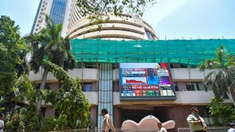 Mumbai: People walk past a screen showing stock market goes down outside BSE building at Dalal Street after the counting of votes for Lok Sabha polls, in Mumbai on Tuesday, June 4, 2024.