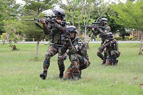 Indian army soldiers carrying out a security drill in an open landscape