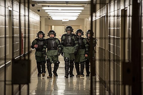 An ERO SRT team walks through a detention facility in riot gear