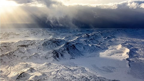 A Himalayan glacial lake amid mountain terrain, representing climate threats and data invisibility.