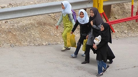 Woman in Tehran without hijab walking the street in public protest.
