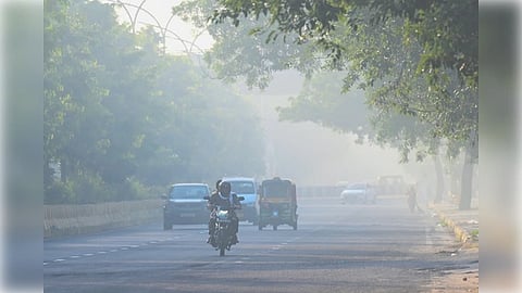 Noida: Commuters move along a road on a smoggy morning as air pollution levels rise, in Noida on Wednesday, October 15, 2025.