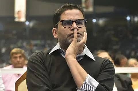 In the image Prashant Kishor is shown looking at something he is wearing shirt and sweater