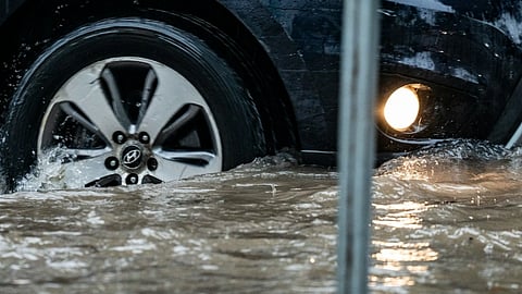 Image of a car driving through heavy rainfall and water logging