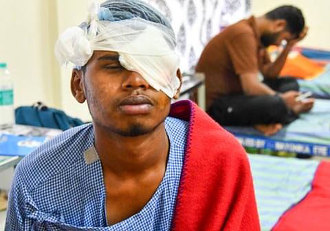 Image of a man sitting in hospital with his left eye covered in bandages due to injury caused by fire crackers.