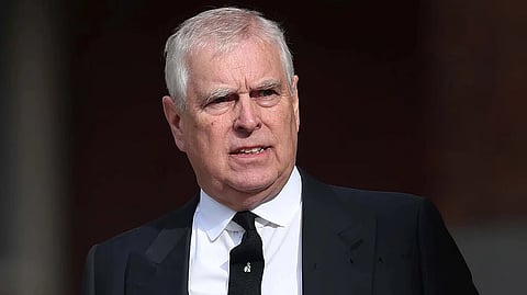 Image of Prince Andrew brother of King Charles wearing a black formal suit. there is a tiny brooch on his tie.