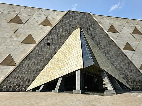 The main gate of the Grand Egyptian Museum with a motif of hieroglyphs behind it.