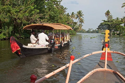 In the image Kerala backwaters, Boat is shown where kerala people are sitting on the boats