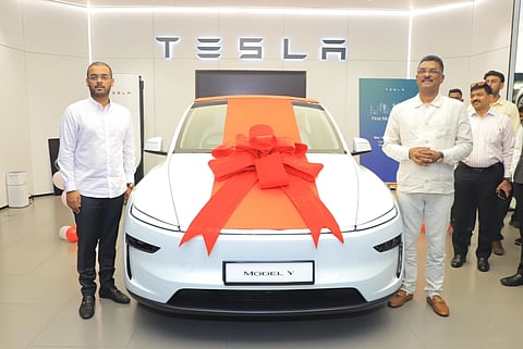 Image of Maharashtra Transport Minister and Shiv Sena leader Pratap Sarnaik (on the right) receiving India's first Tesla's Model Y in Mumbai showroom. The Electric Vehicle has a huge red bow on it.