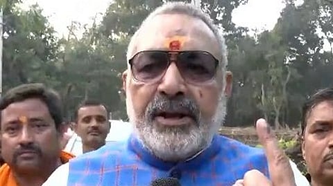 Union Minister Giriraj Singh showing up his index finger marked with ink after voting. He is wearing specs and a tilak.