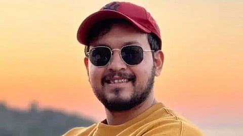 In the image Arunay Sood is shown posing before the sunset with glasses