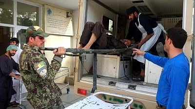 People carry an injured man after a traffic accident in a ambulance. One is in uniform.