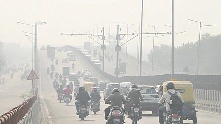 Commuters wade through heavy smog and pollution engulfing New Delhi on Friday, November 14, 2025.