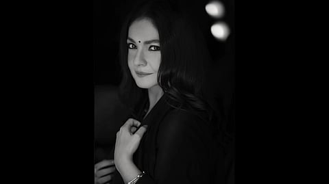 A black and white portrait of Pooja Bhatt of her side profile. She is wearing a Bindi and kajal.