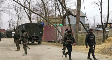 In the image army officers are shown patrolling in a region with trees