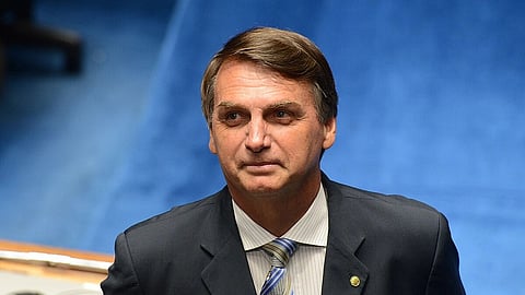 In the image Jair Bolsonaro is shown wearing a blue coat, shirt and tie