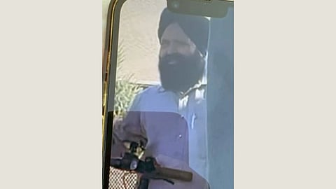 Image of Jagjit Singh's photograph on a Smartphone screen reflection. The man is seen with a beard and turban, wearing a light shirt, against a blurry outdoor background.