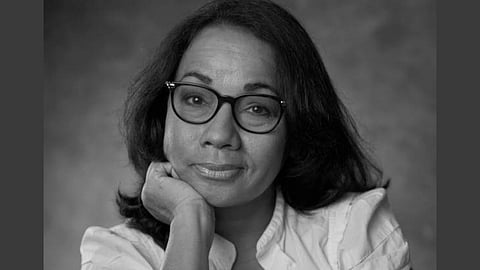 Trinidadian Filmmaker Danielle Dieffenthaller posing to the camera she is wearing a white top with glasses