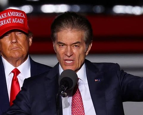 Image of Centers for Medicare and Medicaid Services Administrator Mehmet Oz speaking. behind him is Trump wearing a red cap with MAGA written on it.