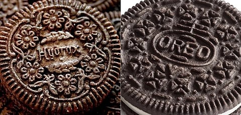 Image of Close-up of two chocolate cookies side by side: Hydrox and Oreo. The left cookie features intricate floral designs and the word "Hydrox," while the right displays the name "Oreo."