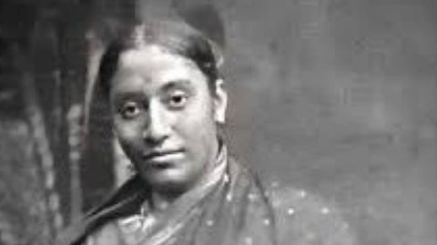 Image of Black and white portrait of Rukhmabai in a sari, looking at the camera with a calm expression. The background is soft and blurred, creating a serene tone.