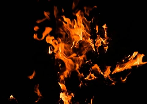 Vivid orange and yellow flames flicker against a dark background, creating a dynamic, intense, and energetic scene full of warmth and motion.