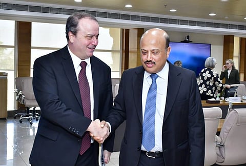 Image of Deputy U.S. Ambassador for Trade Rick Switzer and commerce secretary rajesh Aggrawal shaking their hands. In the image they shake hands in a conference room, conveying a professional and cordial atmosphere. People converse in the background.