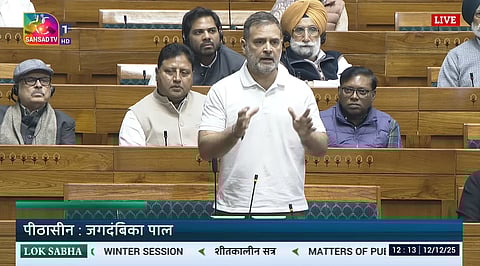 This image is a screenshot of Sansad TV depicting Rahul Gandhi speaking in the Lok Sabha. Other MPs are sitting behind him.