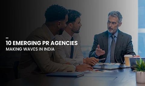 Group of business professionals sitting at a conference table, engaged in discussion. Text overlay reads "10 Emerging PR Agencies Making Waves in India."