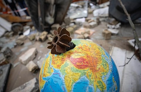 Image of Russo-Ukrainian War. in the image A rusted, spent missile lodged into a colorful globe, symbolizing conflict with scattered debris in the background, conveying a sense of world unrest.