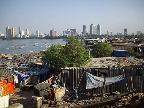 View of "Skyscraper Worli Buildings" from ancient "Worli Village". Skycrapers in th background, a slum in the forground, seperated by a body of water.