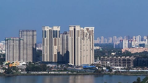 Several high rise building as seen from across a body of water in Kolkata, with more in the background.