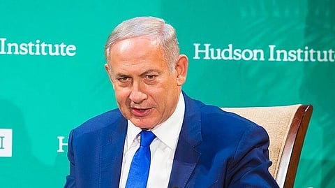 In the image Netanyahu is shown looking at the camera his hands are in the air and he is speaking wearing a formal suit