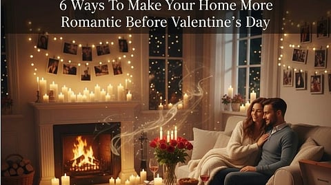 Cozy living room with couple embracing on a sofa, surrounded by candles, string lights, and flowers. A fireplace glows below a Valentine's Day decor.