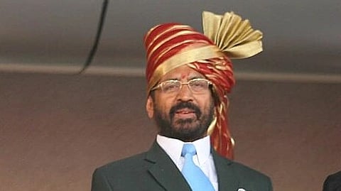 In the image Suresh Kalmadi is shown looking at the audience with a red turban