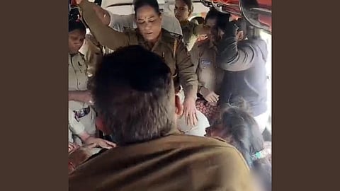 A crowded scene inside a vehicle with several police officers in uniform and civilians. One officer is standing, appearing focused and alert. Tense atmosphere.
